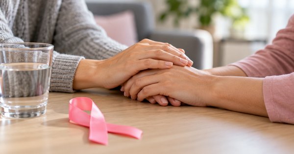 Manos en una escena genérica de acompañamiento, con una cinta rosa